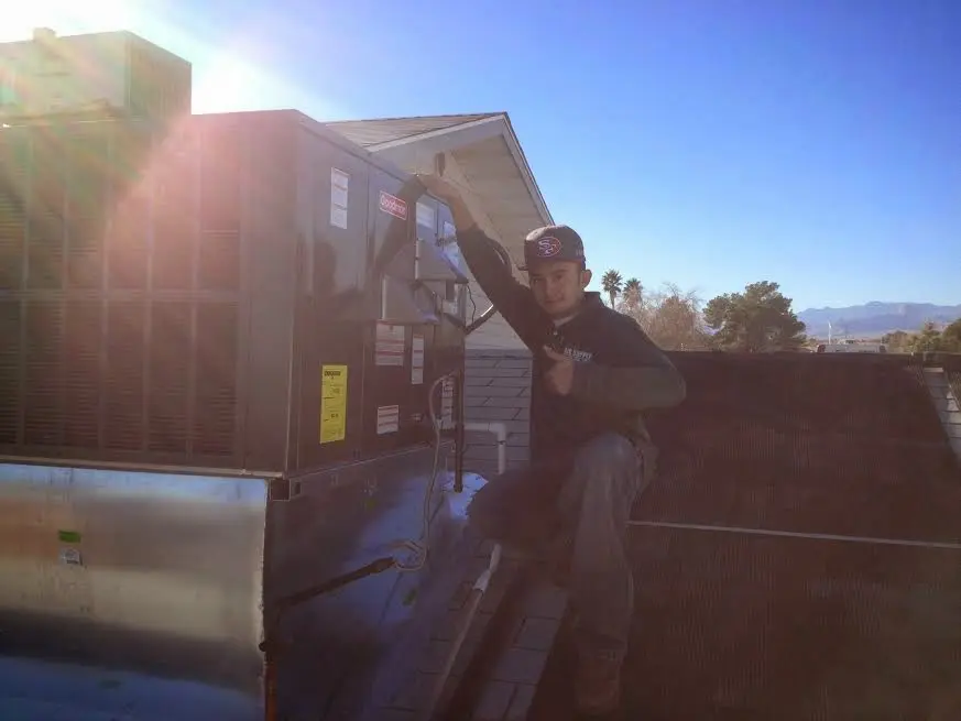 HVAC technician performing Boiler Repair on a rooftop unit in Mauldin